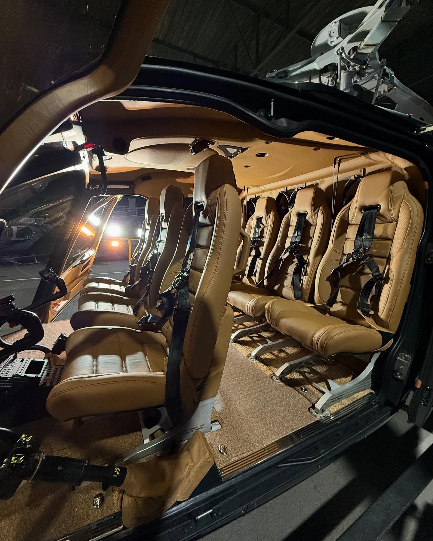 Row of tan leather executive helicopter seats after cabin detail
