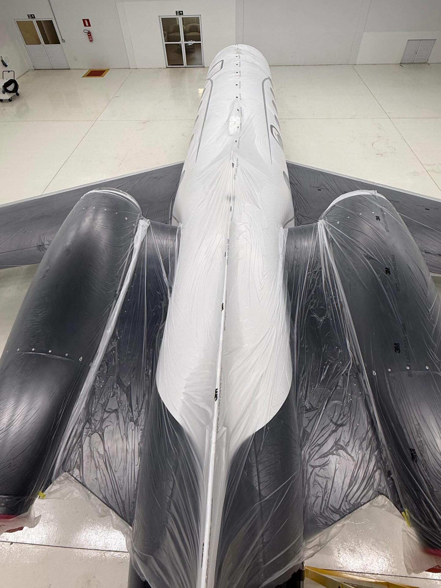 Polished executive jet fuselage in a hangar